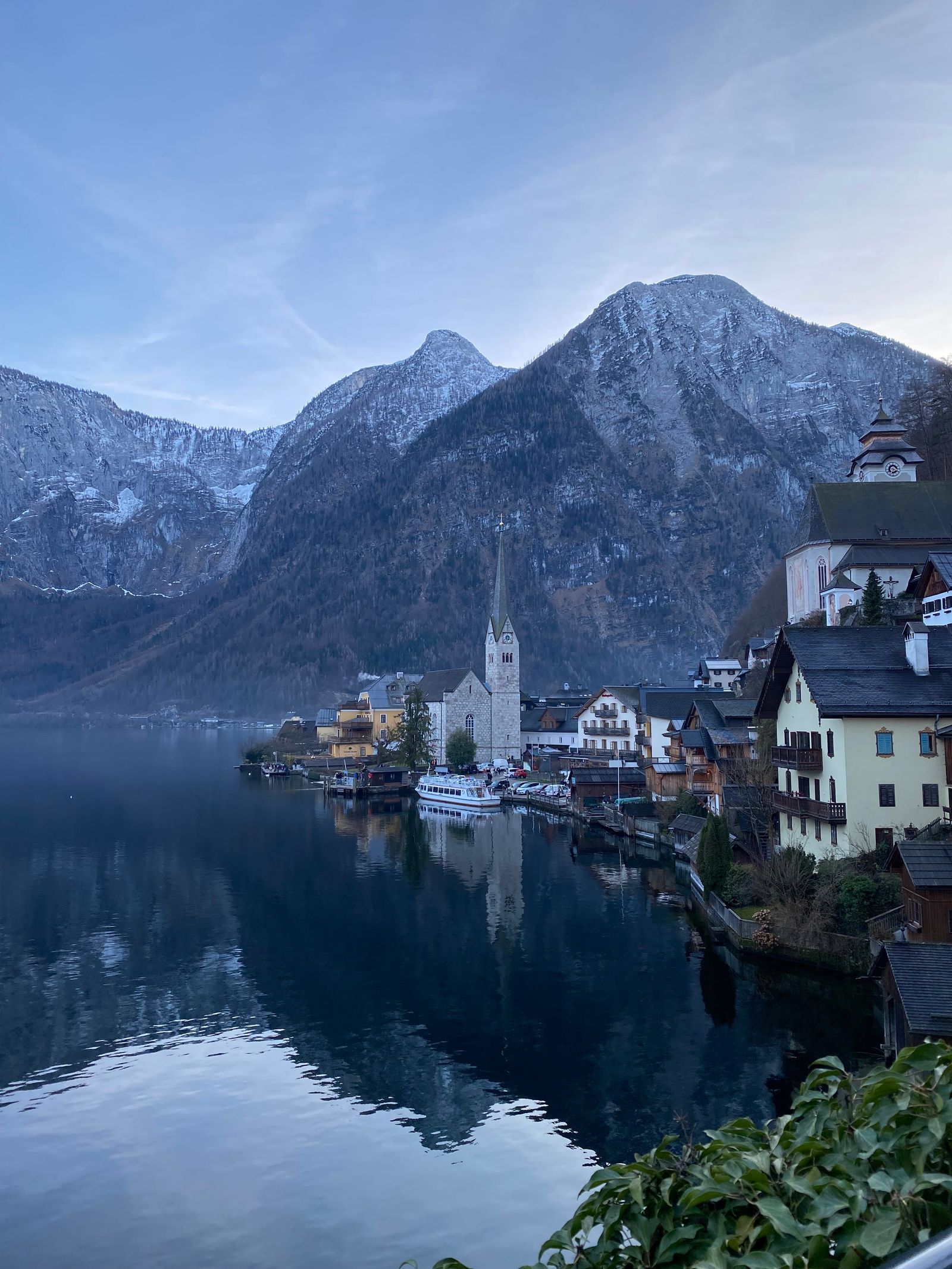 Verschneite Häuser von Hallstatt am See mit Bergen im Hintergrund