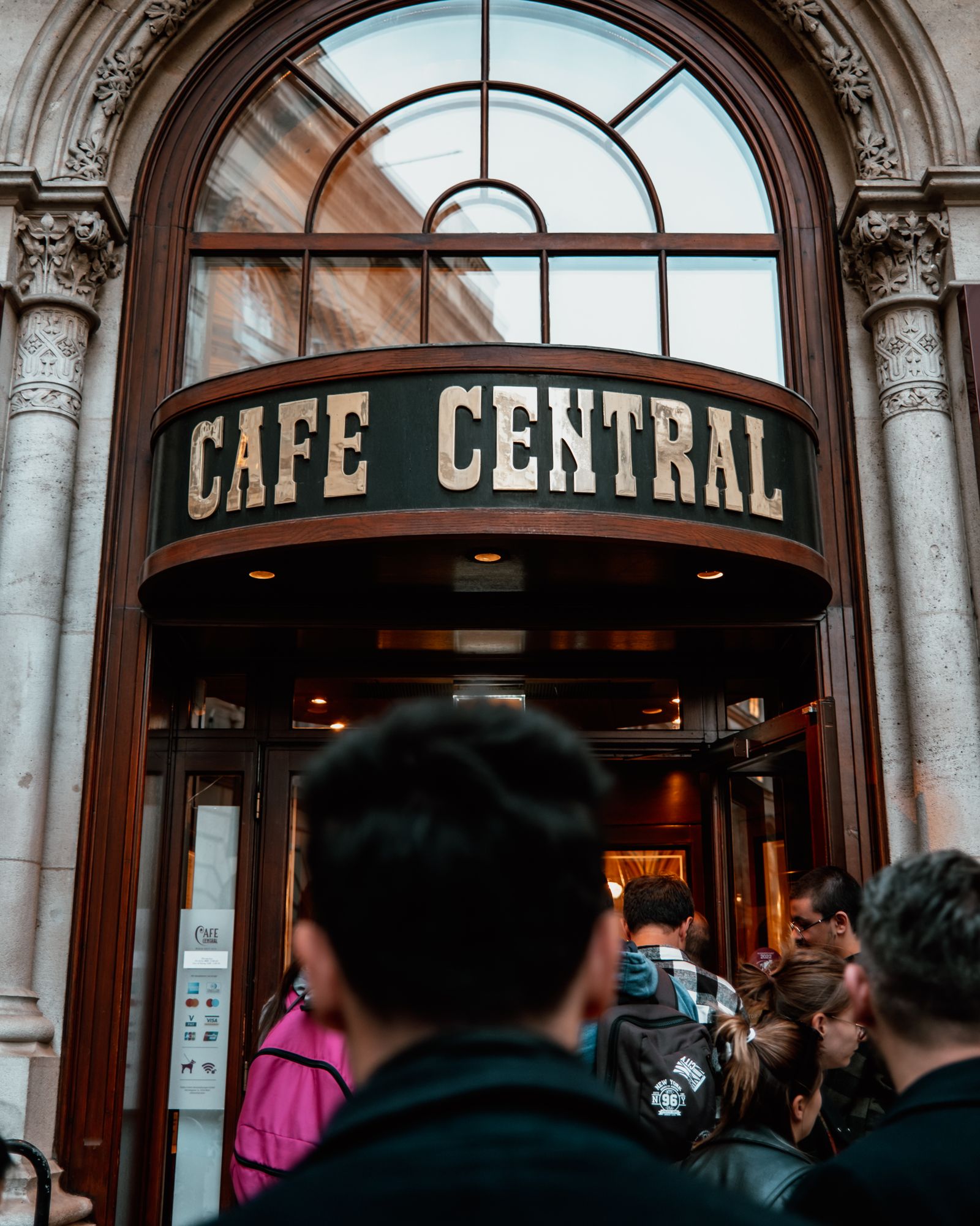 Menschen vor dem Eingang eines historischen Wiener Kaffeehauses