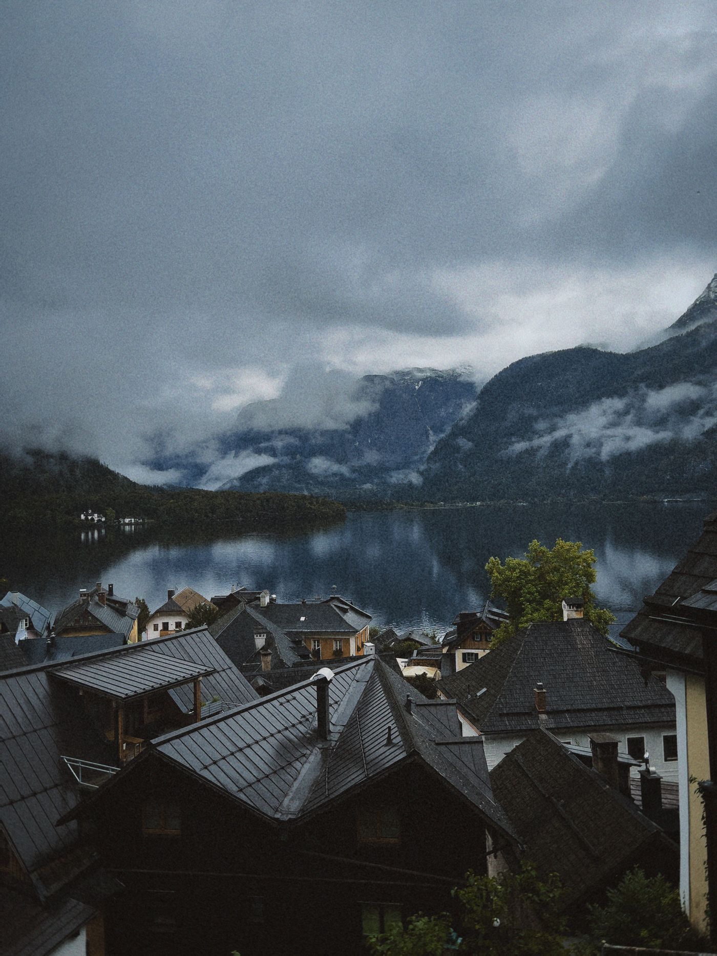Alpensee mit Dorf und Bergen im Hintergrund